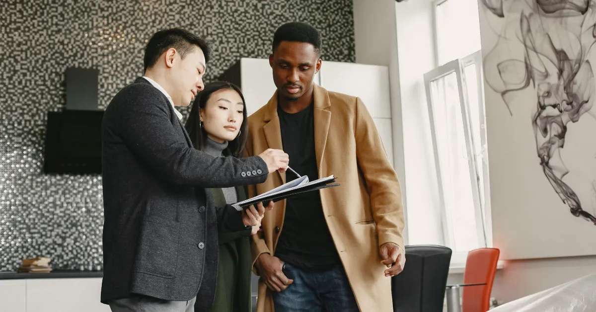 Realtor discussing paperwork with clients about average cost to install water softener at home.