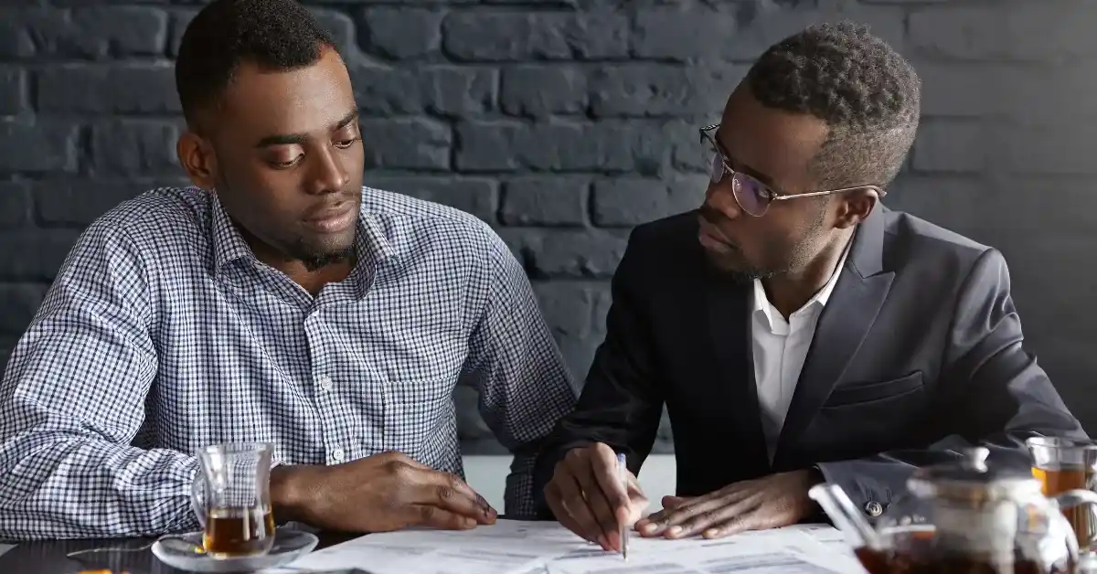Two men reviewing documents about cost of a water softener installed and home service pricing.